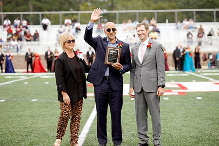 Macon native Larry Anderson, center, is East Mississippi Community College’s 2024 Alumnus of the Year. He is presented his award during the college’s Sept. 28 Homecoming game by EMCC President Scott Alsobrooks, at right, and Executive Director of Alumni Affairs and Foundation Operations Gina Cotton. 