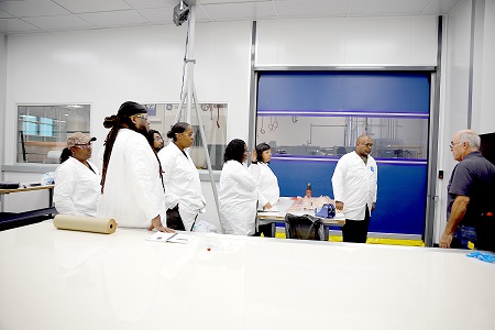 A group of composite technicians who work for a company that develops advanced materials in manufacturing process technologies used in the aviation industry participate in a class in the Mississippi Advanced Composites Training Center at The Communiversity. Here, an instructor shows them how to operate a Gerber laser system located in a clean room set up in the training center.